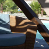 Sedia in vimini accanto a una piscina soleggiata.