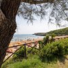 Spiaggia con ombrelloni arancioni e mare sullo sfondo.