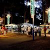 Una fiera luminosa di notte con persone e bancarelle.