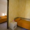 Camera con un letto matrimoniale e uno singolo. Pareti gialle.