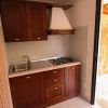 Cucina compatta con mobili in legno e lavello.