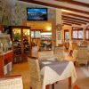 Ristorante con tavoli e televisione accesa.