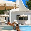 Persone rilassate vicino a una piscina con ombrelloni.