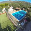 Piscina rettangolare accanto a un campo da calcio.