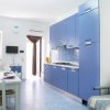 Cucina azzurra moderna con tavolo bianco.