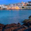Vista notturna di una città costiera illuminata.