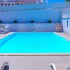 Piscina azzurra con area relax e sedie a sdraio.
