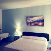 Camera da letto con parete azzurra e dipinto di vela.