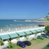 Spiaggia con mare, auto parcheggiate.